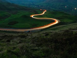 aerial-view-of-road-between-green-grass-field-3635300
